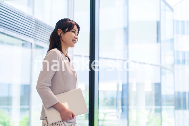 オフィスの中で笑顔で歩くビジネスウーマン