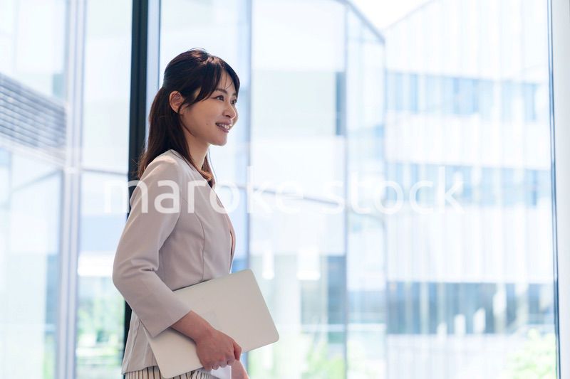 オフィスの中で笑顔で歩くビジネスウーマン