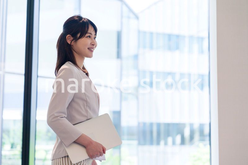 オフィスの中で笑顔で歩くビジネスウーマン