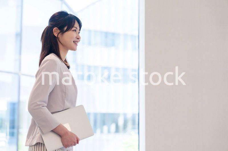 オフィスの中で笑顔で歩くビジネスウーマン