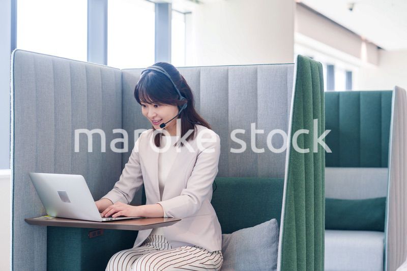 コワーキングスペースのブースで働く若い女性