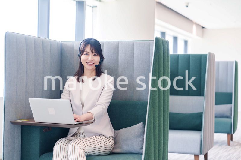 コワーキングスペースのブースで働く若い女性