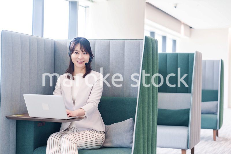 コワーキングスペースのブースで働く若い女性