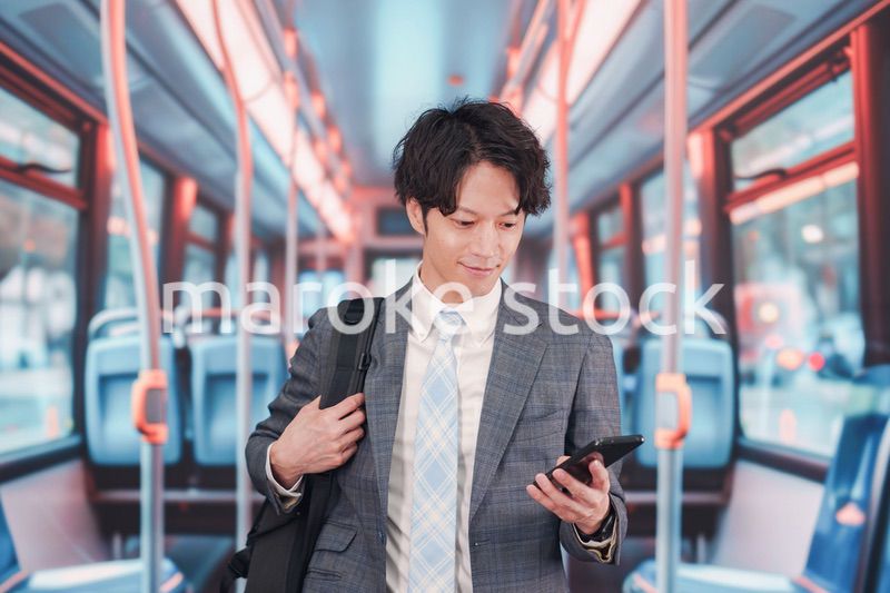 バスで通勤をするスーツを着たビジネスマン
