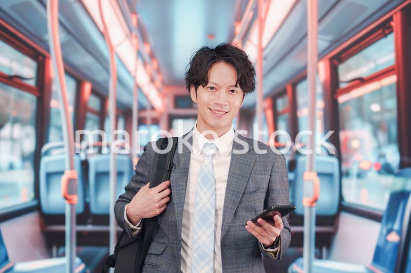 バスで通勤をするスーツを着たビジネスマン