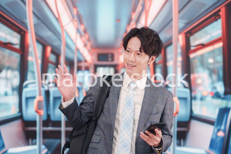 バスで通勤をするスーツを着たビジネスマン