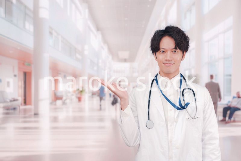 明るい病院で働く白衣を着た若い男性ドクター