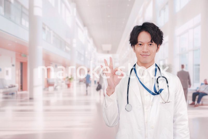 明るい病院で働く白衣を着た若い男性ドクター