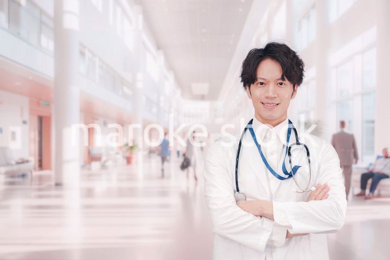 明るい病院で働く白衣を着た若い男性ドクター