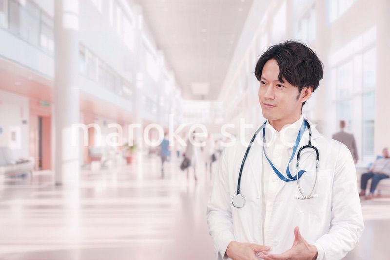 明るい病院で働く白衣を着た若い男性ドクター