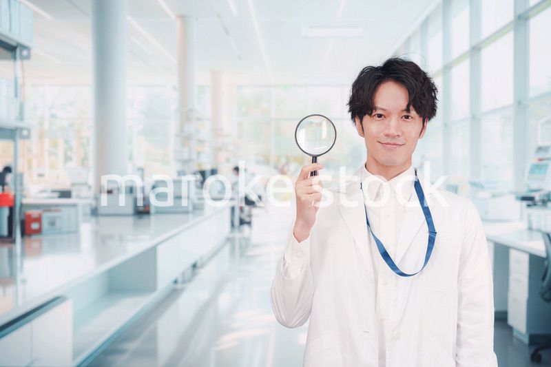 虫眼鏡を持つ白衣を着た男性