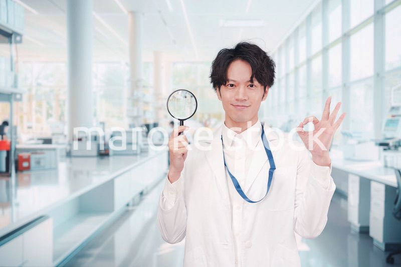 虫眼鏡を持つ白衣を着た男性