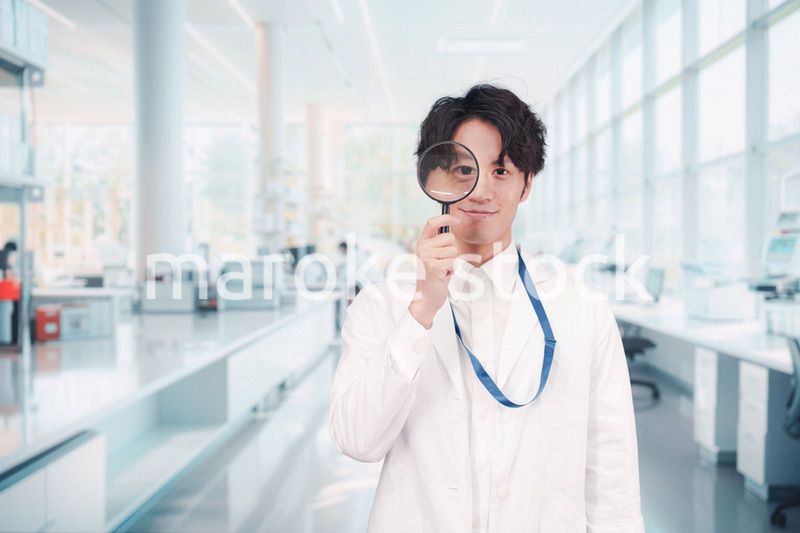 虫眼鏡を持つ白衣を着た男性