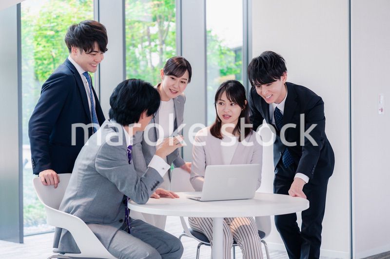 オフィスで笑顔で打ち合わせをするビジネスパーソン