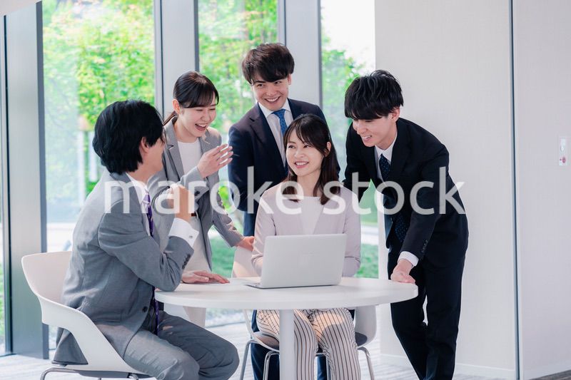 オフィスで笑顔で打ち合わせをするビジネスパーソン