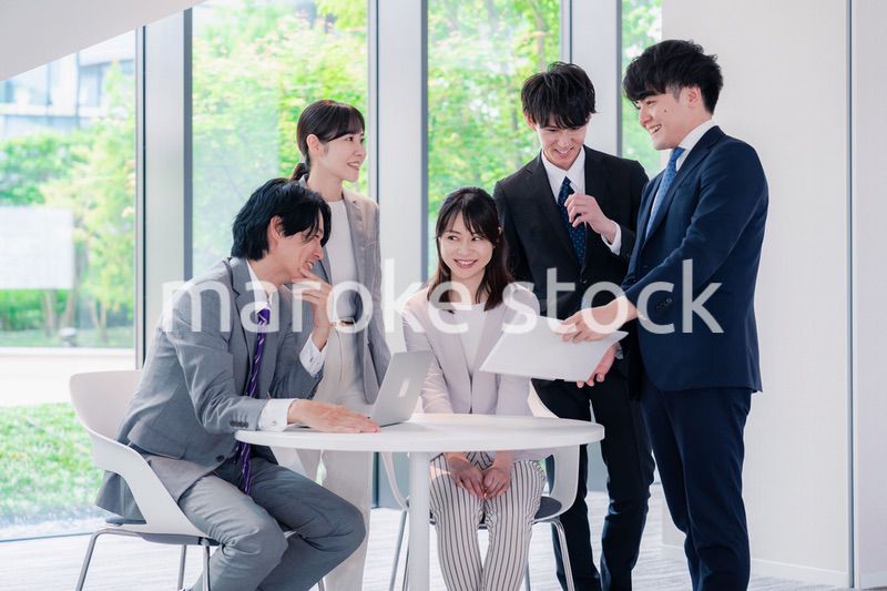 オフィスで笑顔で打ち合わせをするビジネスパーソン