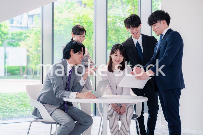 オフィスで笑顔で打ち合わせをするビジネスパーソン