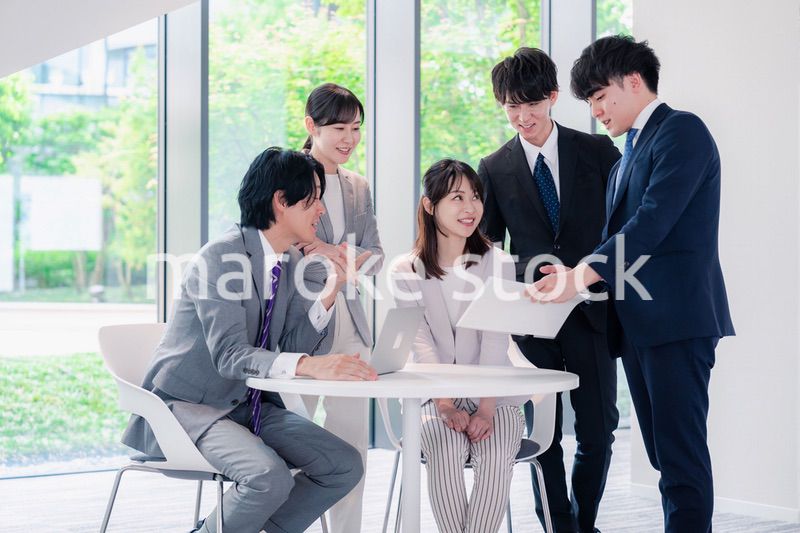 オフィスで笑顔で打ち合わせをするビジネスパーソン