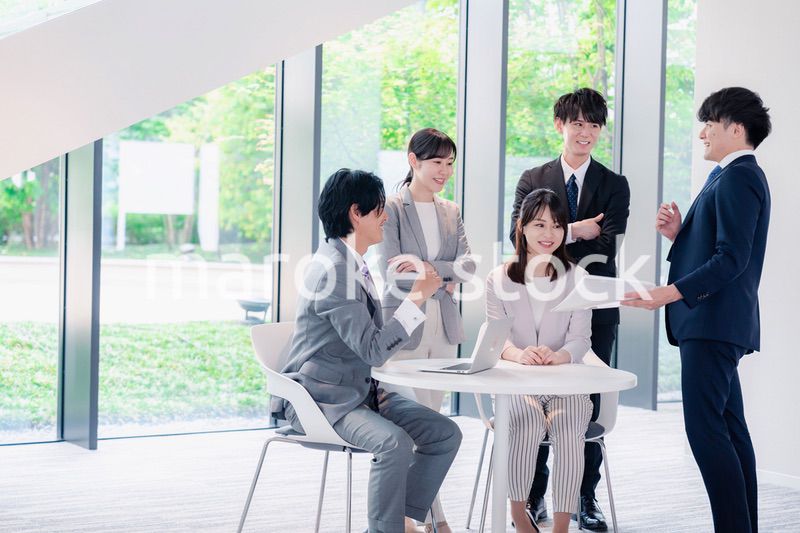 オフィスで笑顔で打ち合わせをするビジネスパーソン