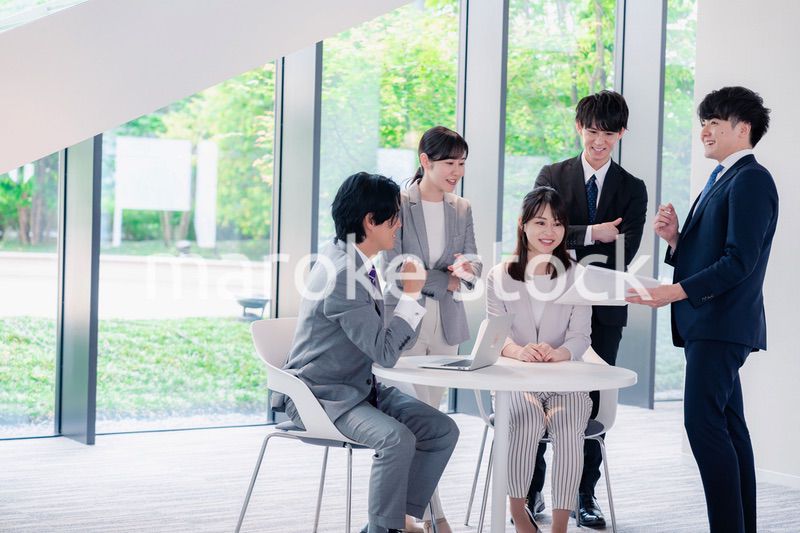 オフィスで笑顔で打ち合わせをするビジネスパーソン