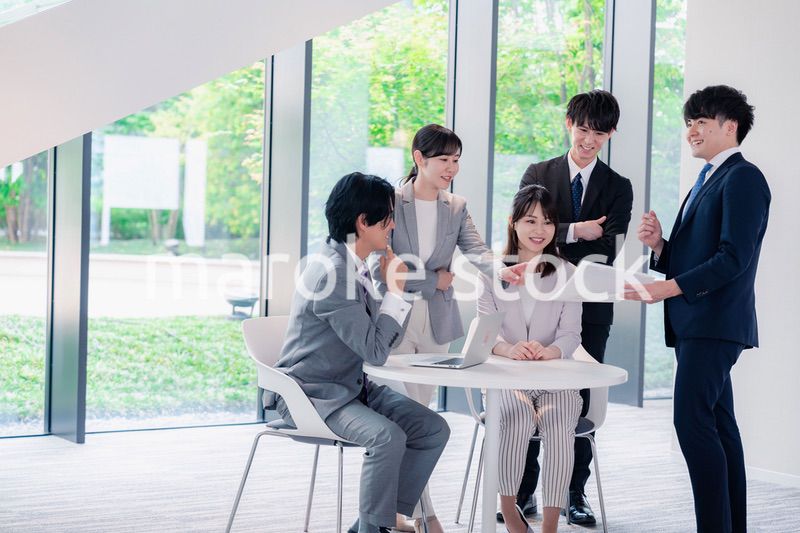 オフィスで笑顔で打ち合わせをするビジネスパーソン