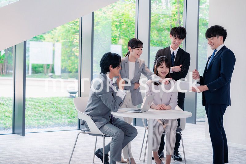 オフィスで笑顔で打ち合わせをするビジネスパーソン