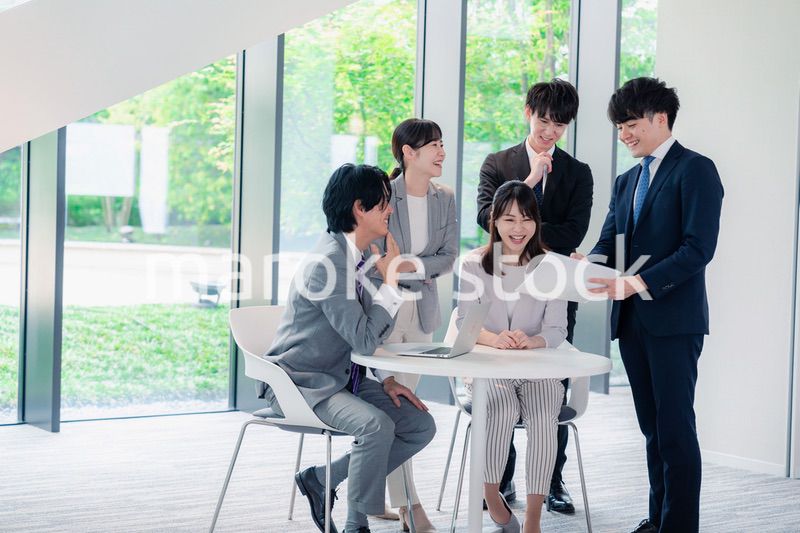 オフィスで笑顔で打ち合わせをするビジネスパーソン