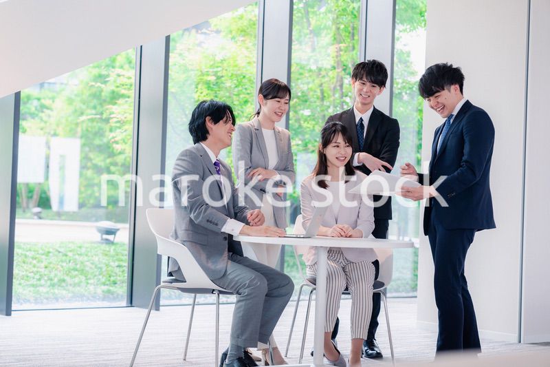 オフィスで笑顔で打ち合わせをするビジネスパーソン