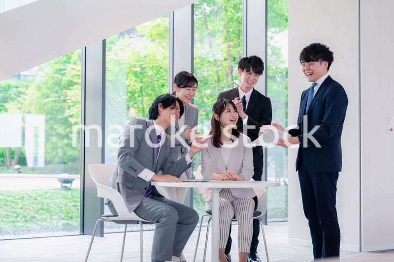 オフィスで笑顔で打ち合わせをするビジネスパーソン