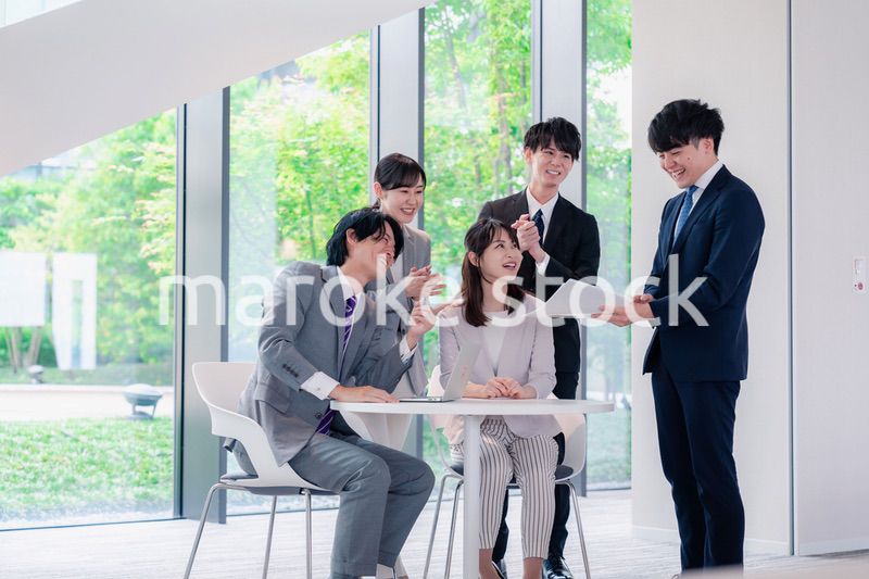 オフィスで笑顔で打ち合わせをするビジネスパーソン