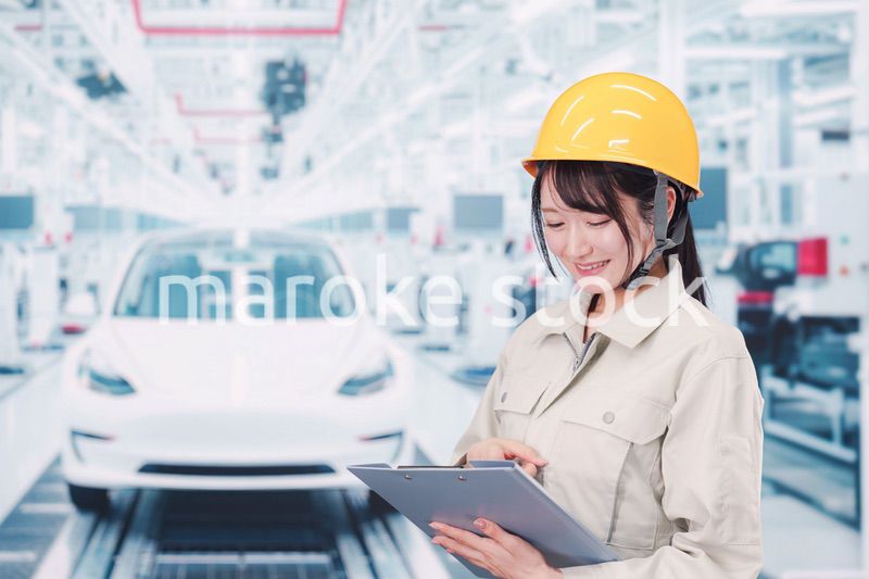 自動車工場の生産ラインで働く若い女性