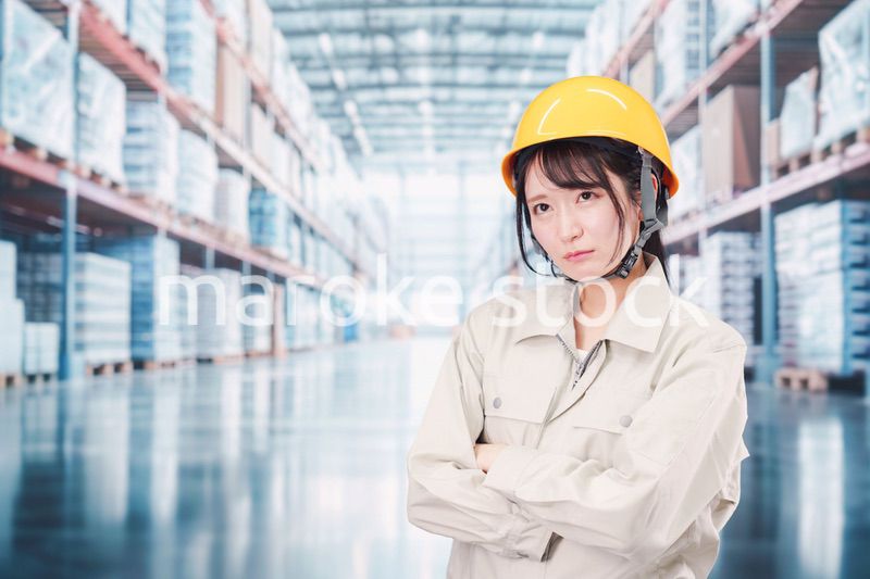 倉庫の中で頭を抱える女性の従業員