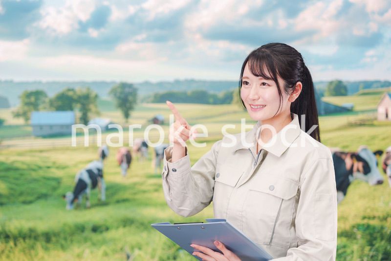 牧場で働く作業服姿の若い女性