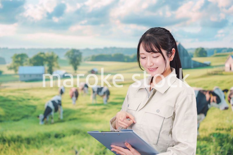 牧場で働く作業服姿の若い女性