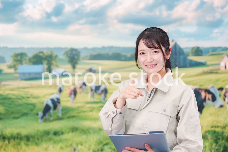 牧場で働く作業服姿の若い女性