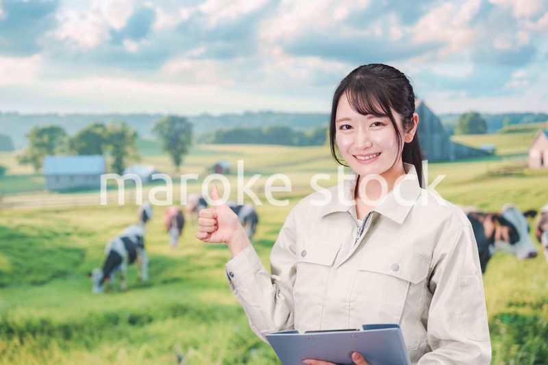 牧場で働く作業服姿の若い女性
