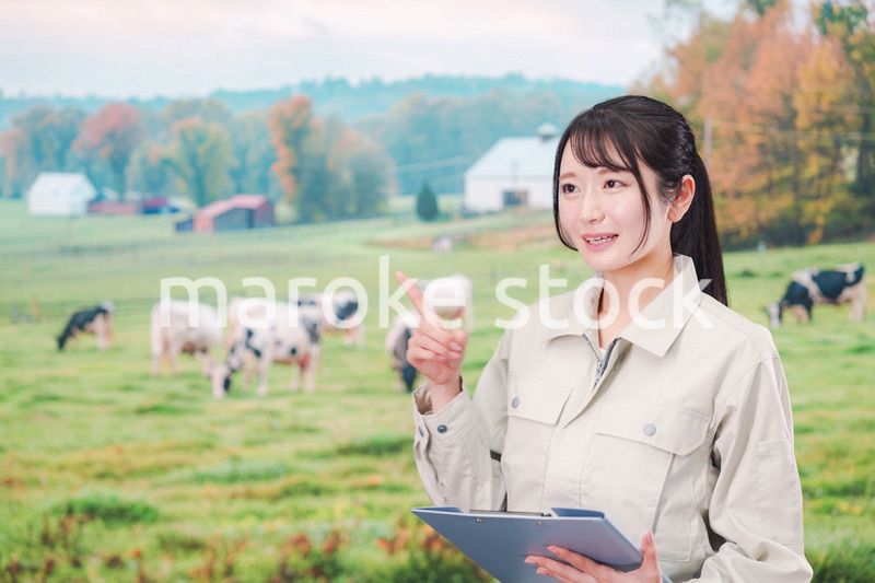 牧場で働く作業服姿の若い女性