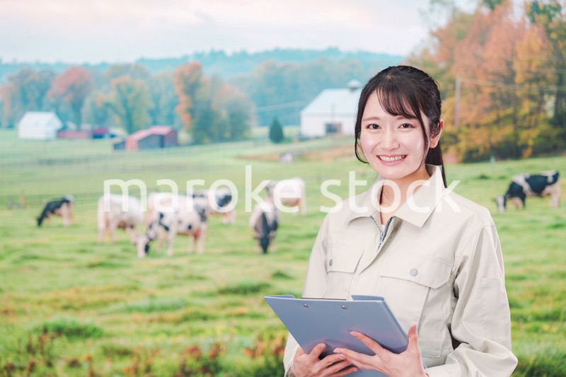 牧場で働く作業服姿の若い女性