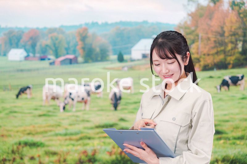 牧場で働く作業服姿の若い女性