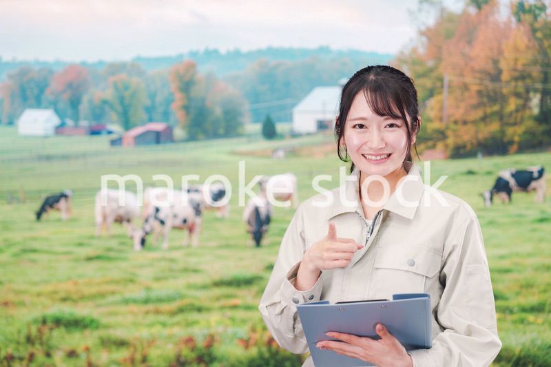 牧場で働く作業服姿の若い女性