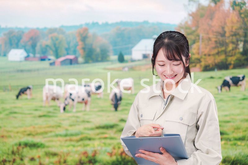 牧場で働く作業服姿の若い女性