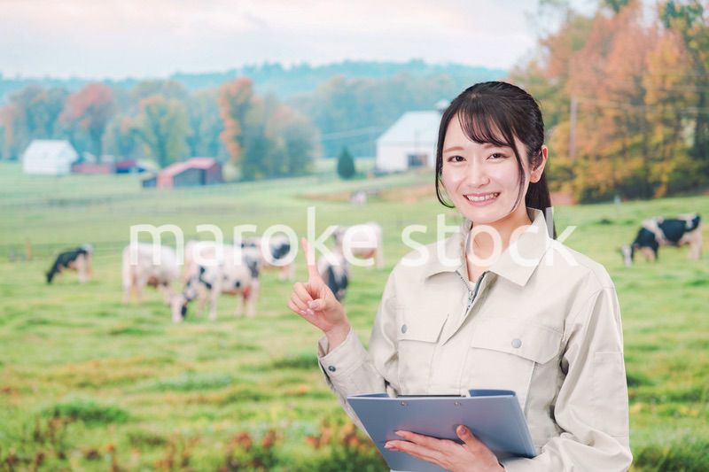 牧場で働く作業服姿の若い女性