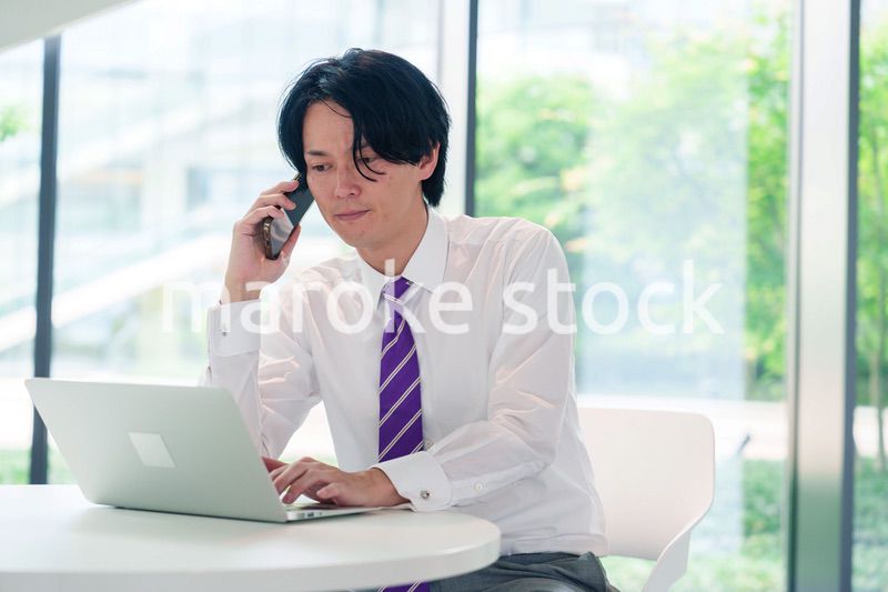 不機嫌な表情で電話をするビジネスマン