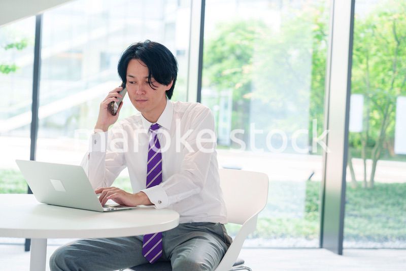 不機嫌な表情で電話をするビジネスマン