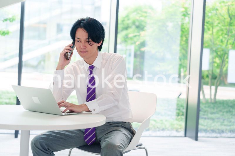 不機嫌な表情で電話をするビジネスマン