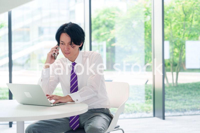 不機嫌な表情で電話をするビジネスマン
