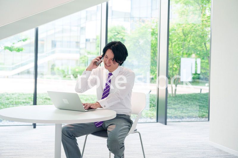 不機嫌な表情で電話をするビジネスマン