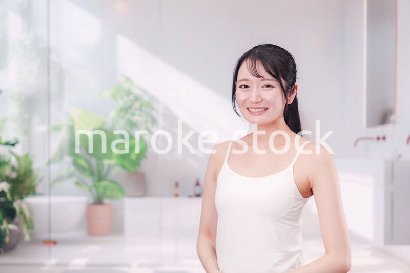 笑顔でビューティーケアをする若い女性