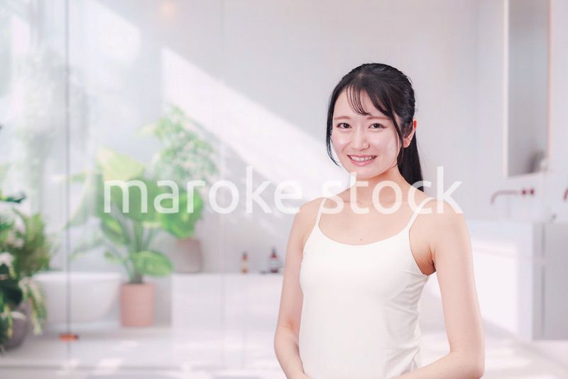 笑顔でビューティーケアをする若い女性