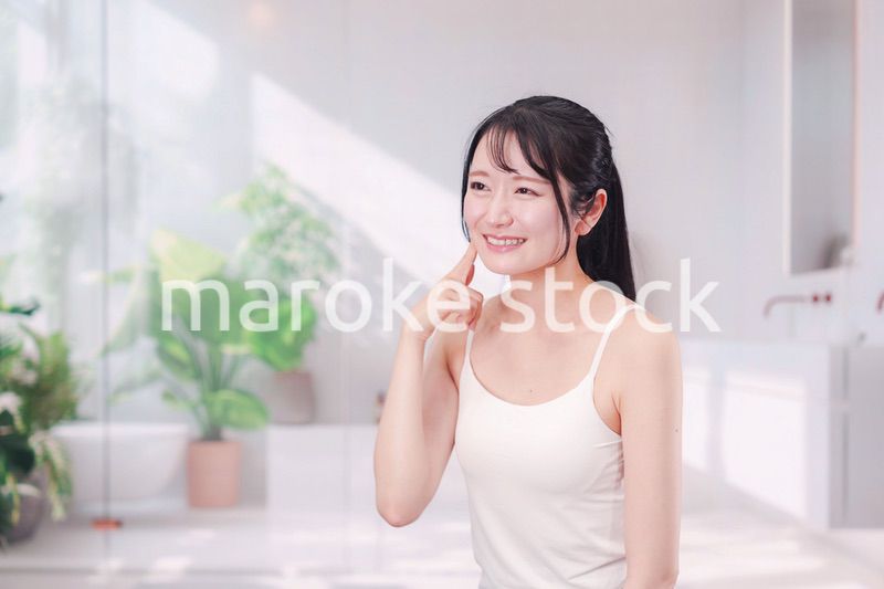 笑顔でビューティーケアをする若い女性